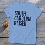 Light blue t-shirt with "SOUTH CAROLINA RAISED" text.