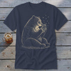 Bear sitting and holding a jar of fireflies on a navy blue t-shirt.