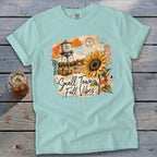Light blue t-shirt with a graphic of a water tower, sunflower, and the text "Small Town Fall Vibes."