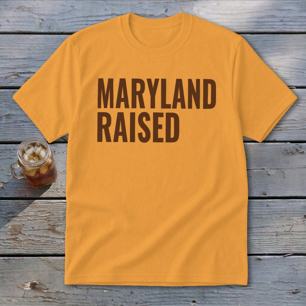 Orange t-shirt with brown text "MARYLAND RAISED" and a glass of iced tea.