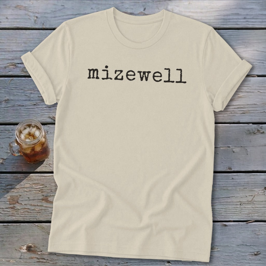Cream t-shirt with black text "mizewell" in typewriter font.