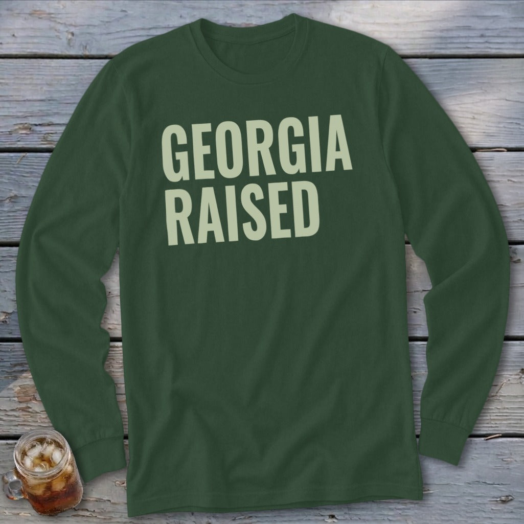 Long sleeve dark green shirt with light tan text "GEORGIA RAISED"