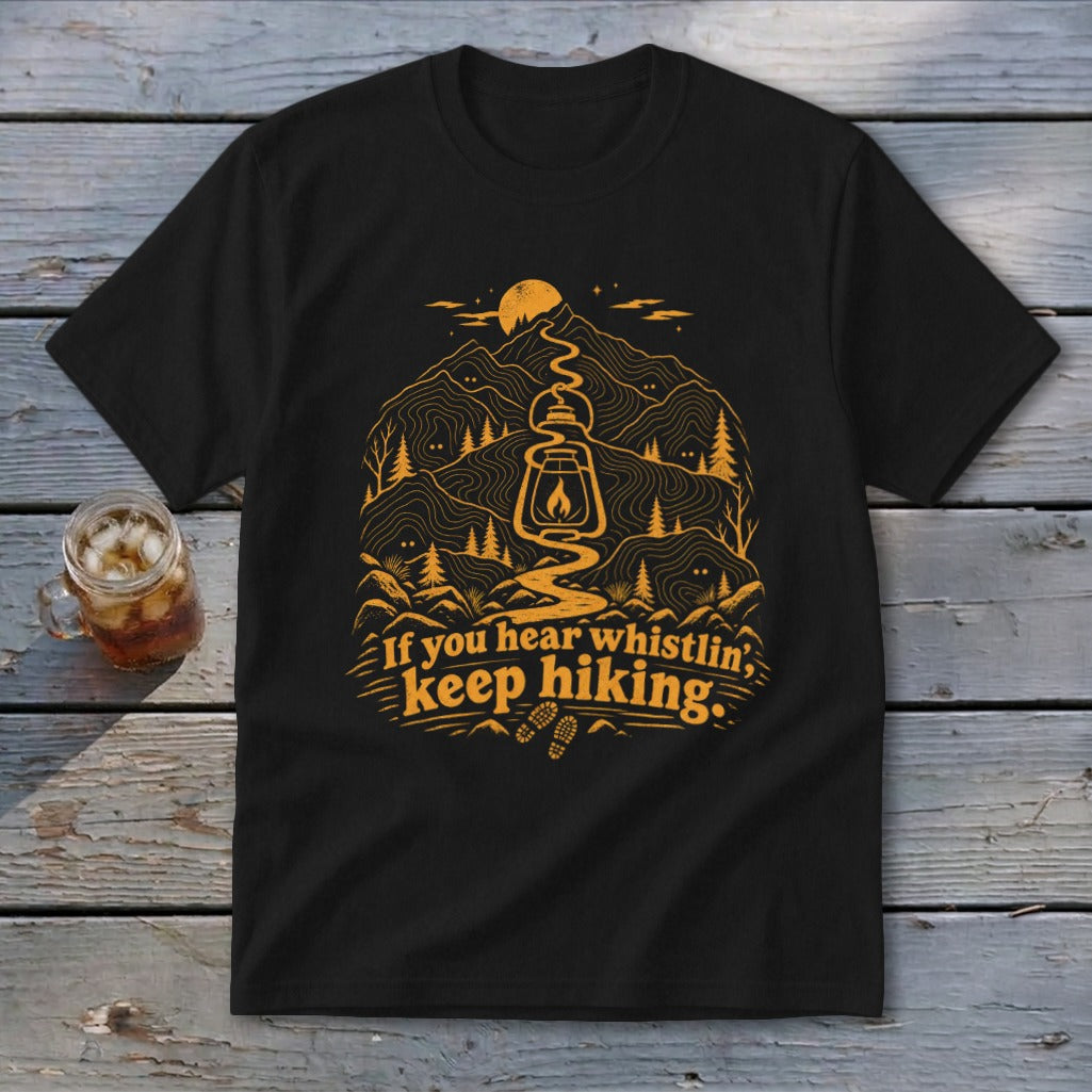 Black t-shirt with mountain, lantern, and text: "If you hear whistlin', keep hiking."