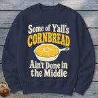 Navy blue crewneck sweatshirt featuring a graphic of yellow cornbread in a skillet and text that reads Some of Yall's Cornbread Ain't Done in the Middle.