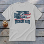 White t-shirt with distressed American flag graphic and text "TENNESSEE RAISED AMERICAN MADE".