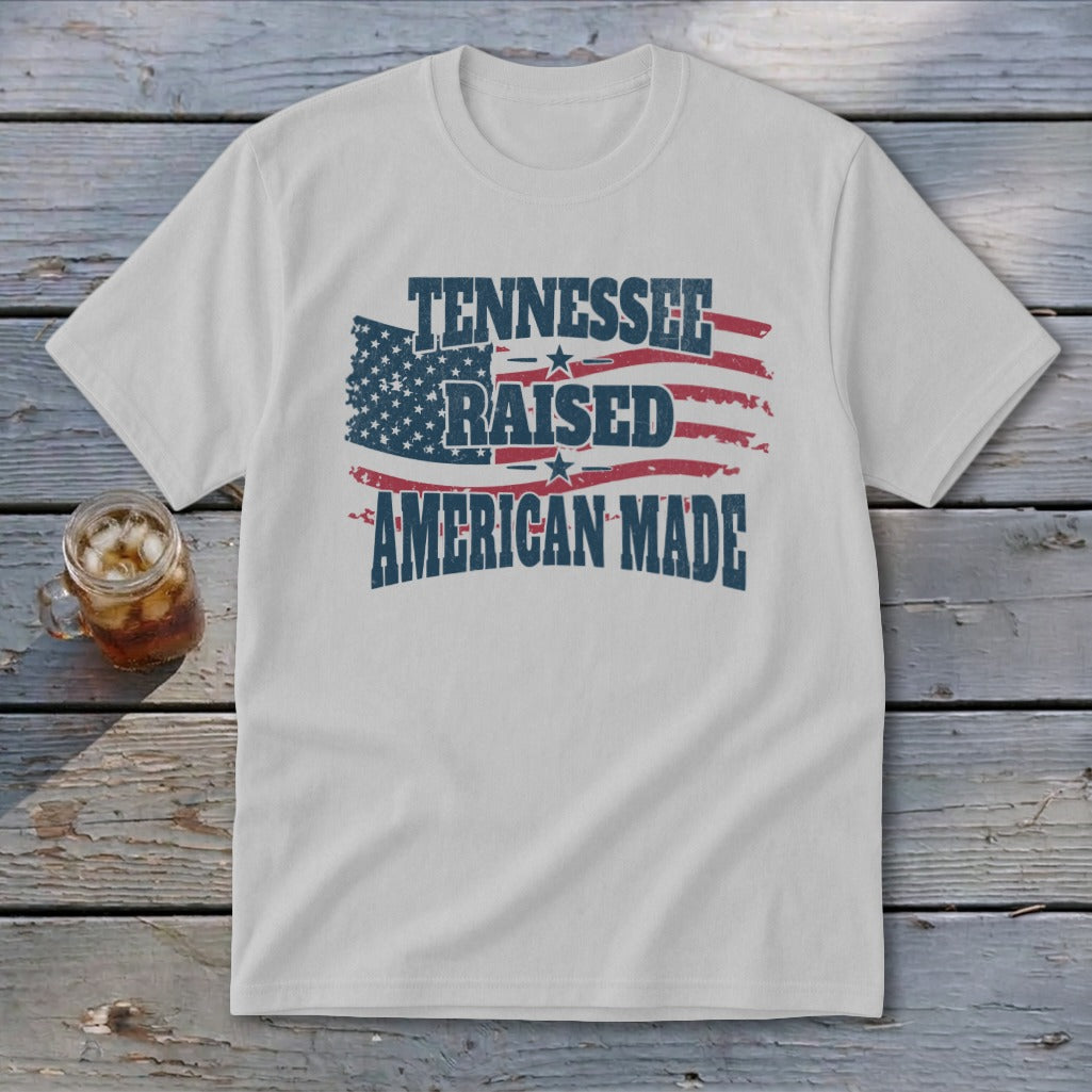 White t-shirt with distressed American flag graphic and text "TENNESSEE RAISED AMERICAN MADE".
