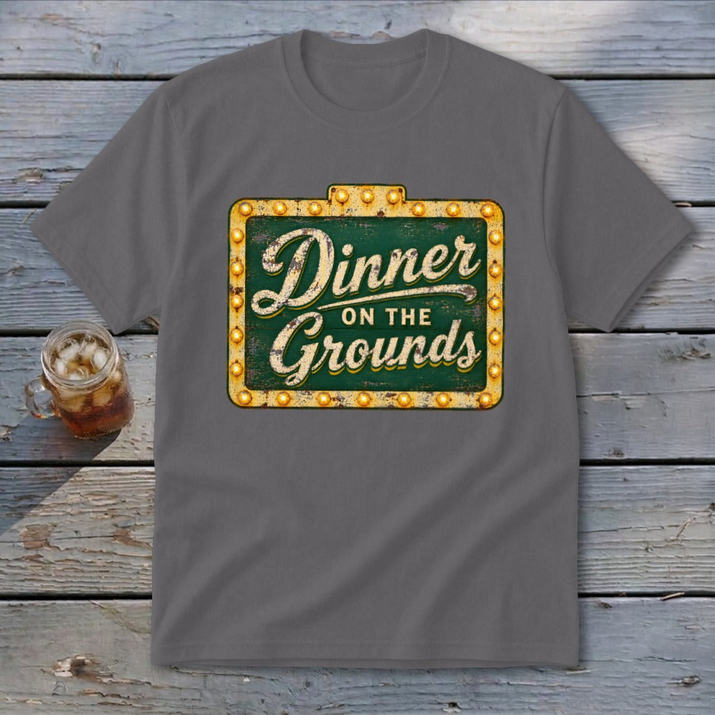 Dark gray t-shirt featuring a green sign graphic with lit bulbs and Dinner on the Grounds text.