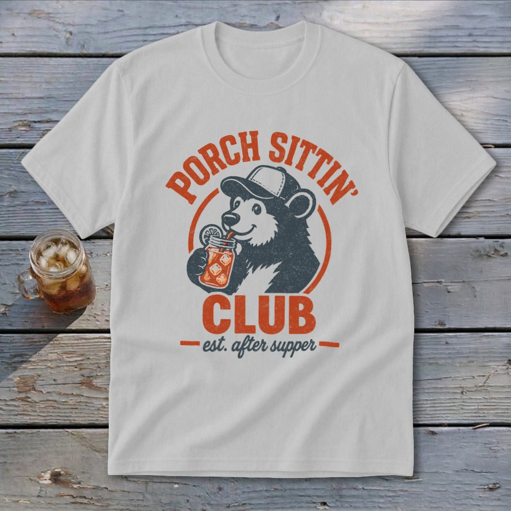 White t-shirt with a bear wearing a cap, drinking from a jar. Text reads "Porch Sittin' Club est. after supper".