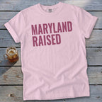 Pink t-shirt with "MARYLAND RAISED" text and a glass of iced tea.