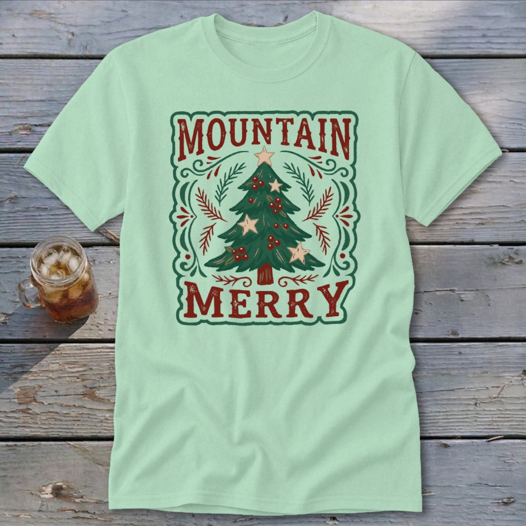 Light green t-shirt with a vintage Christmas tree graphic and the text Mountain Merry.