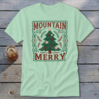 Light green t-shirt with a vintage Christmas tree graphic and the text Mountain Merry.