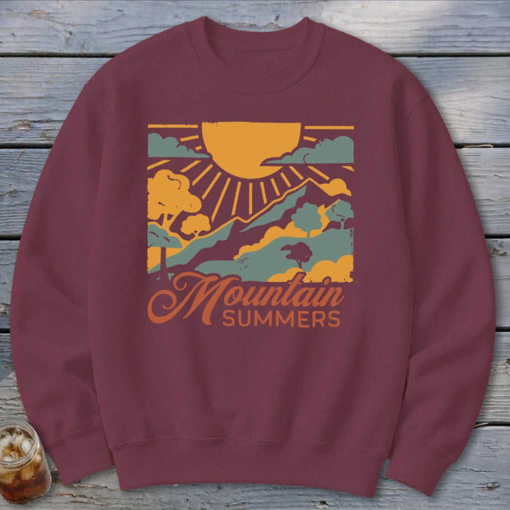 Maroon sweatshirt with "Mountain Summers" text and a stylized mountain landscape graphic.