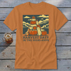 An orange short-sleeve t-shirt with a graphic of stacked pumpkins and the text "HARVEST DAYS IN THE HIGHLANDS."