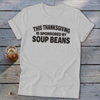 A light gray t-shirt with black text reading THIS THANKSGIVING IS SPONSORED BY SOUP BEANS.