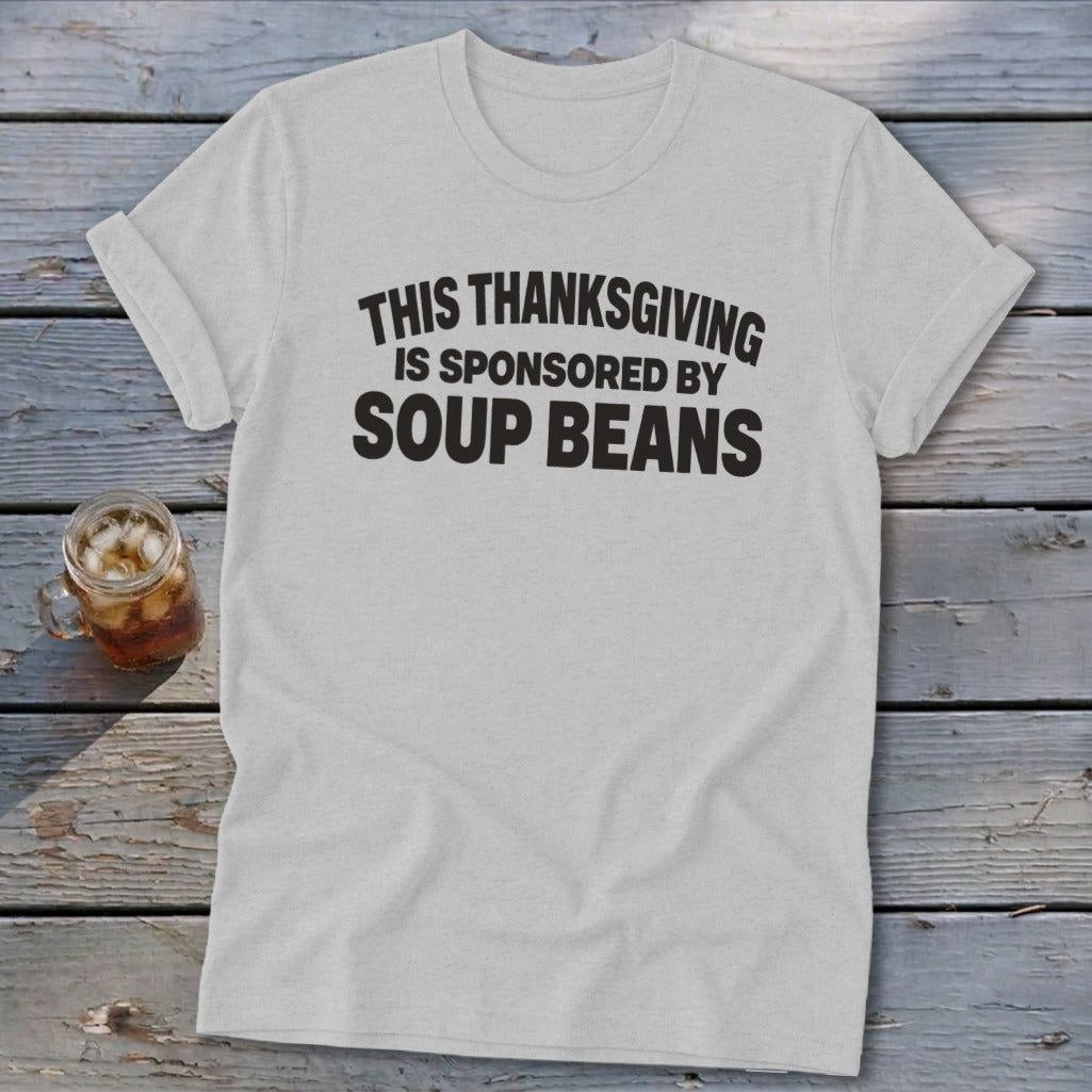 A light gray t-shirt with black text reading THIS THANKSGIVING IS SPONSORED BY SOUP BEANS.