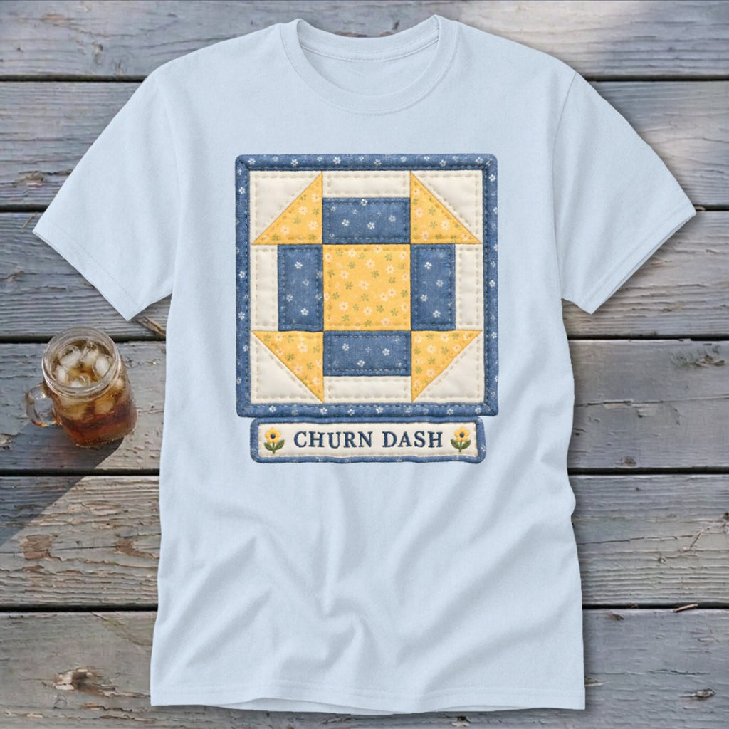Light blue t-shirt with a blue and yellow "Churn Dash" quilt block design.