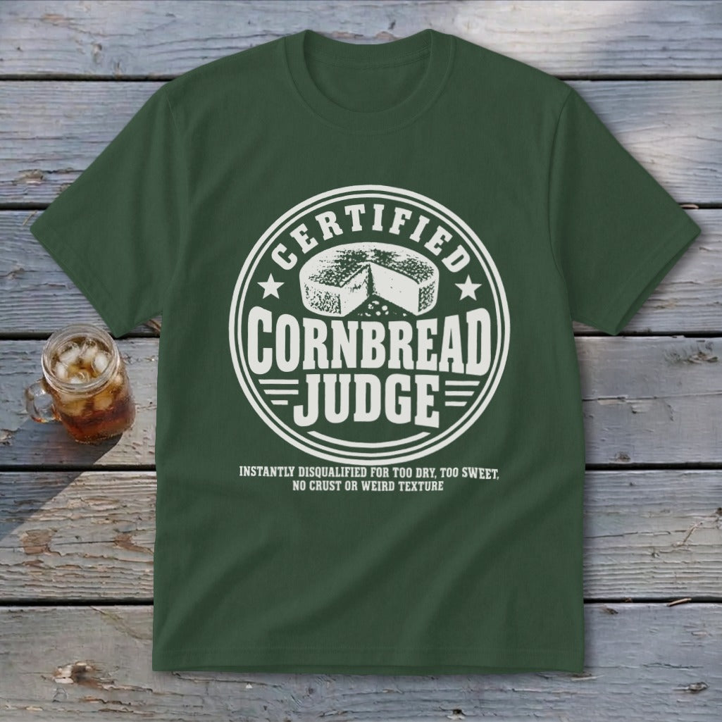 Dark green t-shirt with a white graphic reading Certified Cornbread Judge and a wheel of cornbread.