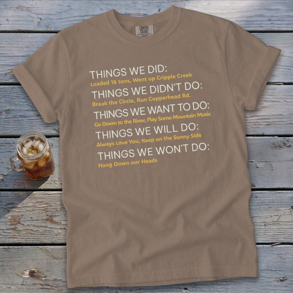 Brown t-shirt with white and yellow text listing "Things we did" and other phrases.