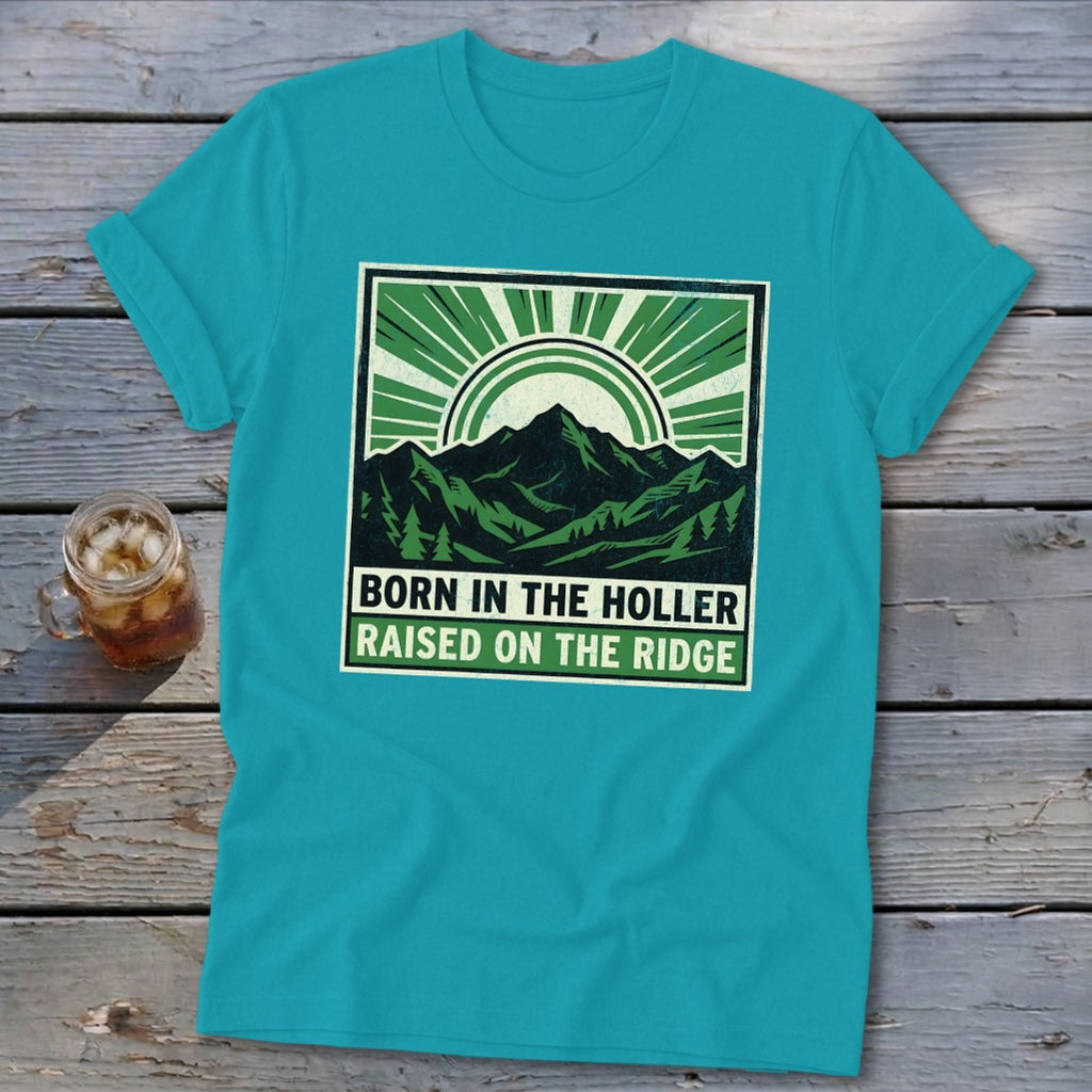 A bright teal t-shirt featuring a green graphic of mountains, trees, and the text Born in the Holler Raised on the Ridge.