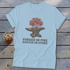 Light blue t-shirt with an anvil and a blooming plant, reading "FORGED IN FIRE ROOTED IN STONE."