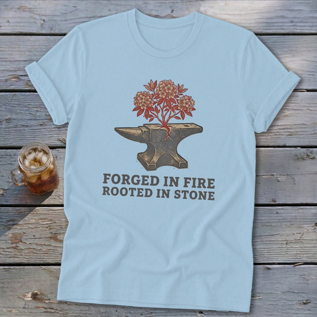 Light blue t-shirt with an anvil and a blooming plant, reading "FORGED IN FIRE ROOTED IN STONE."