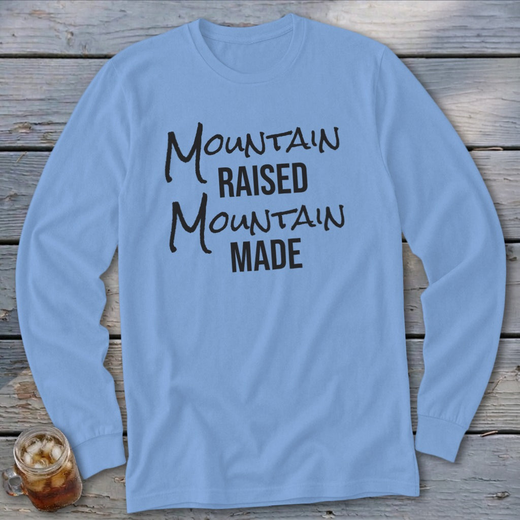 Light blue long-sleeve shirt with black text "Mountain Raised Mountain Made".