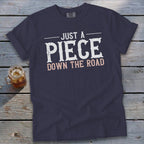 Navy blue t-shirt with "JUST A PIECE DOWN THE ROAD" text.