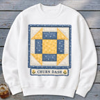 White sweatshirt with a blue and yellow Churn Dash quilt block design.