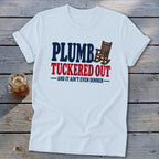 White t-shirt with "PLUMB TUCKED OUT -AND IT AIN'T EVEN DINNER-" text and rocking chair graphic.