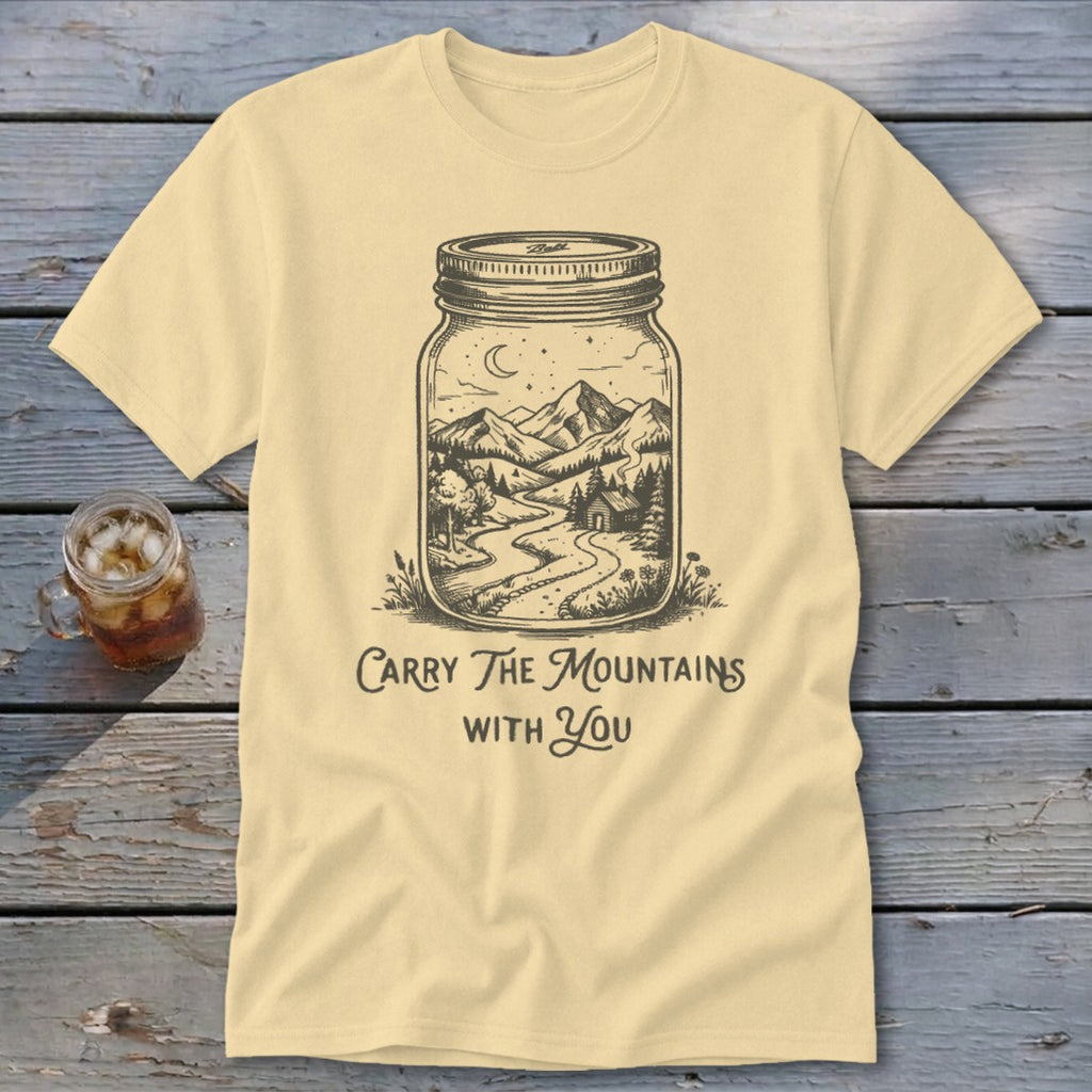 Pale yellow t-shirt featuring a mason jar graphic containing a mountain landscape and text Carry The Mountains With You.
