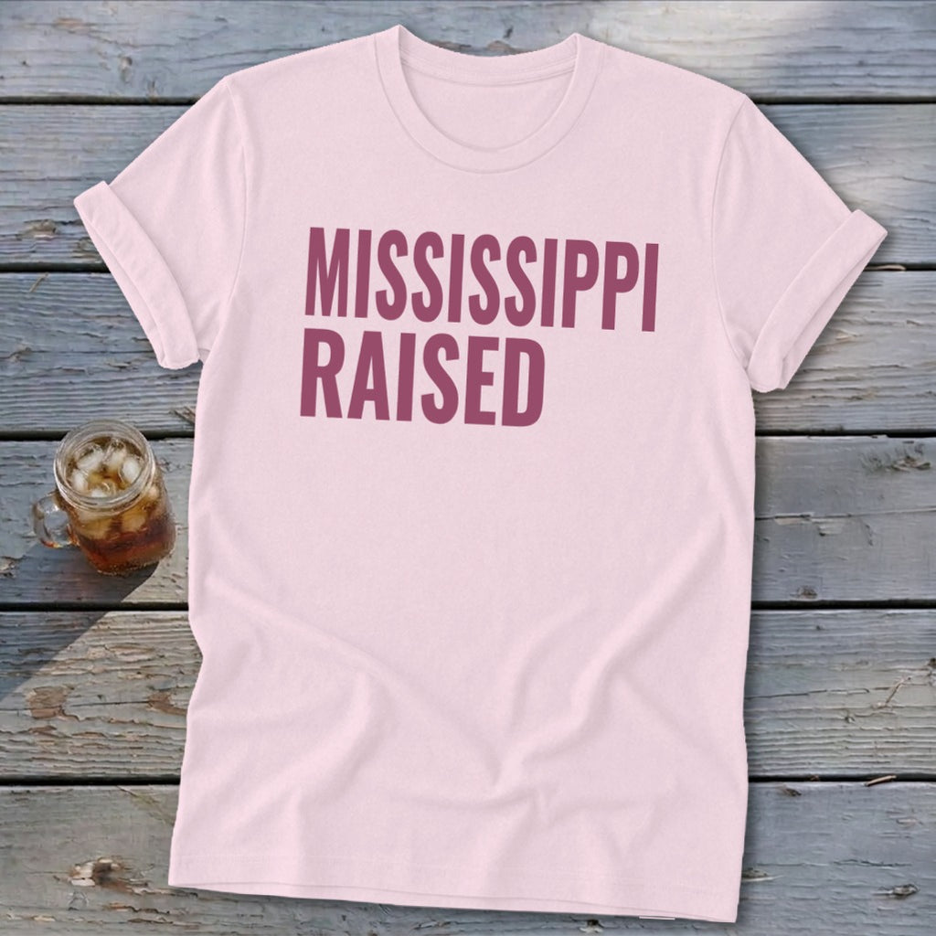 Pink t-shirt with "MISSISSIPPI RAISED" text in maroon.