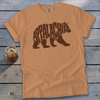 A tan crewneck t-shirt featuring a brown graphic of a bear with Appalachian typography inside.