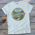 White t-shirt with circular "Tennessee" graphic featuring a scenic mountain river and deer.