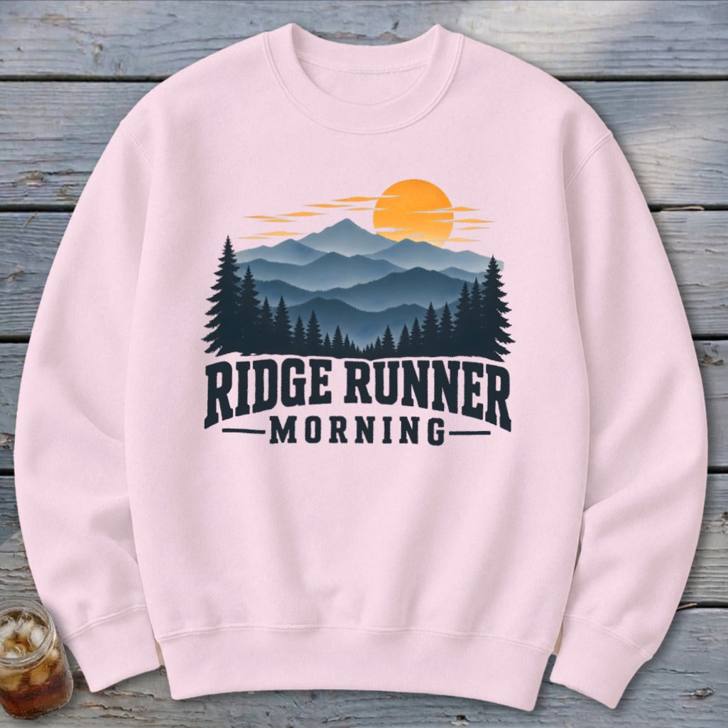 Pink sweatshirt with "Ridge Runner Morning" graphic featuring mountains, trees, and sunrise.
