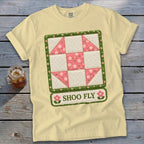 Light yellow t-shirt with Shoo Fly quilt block graphic and pink floral accents.