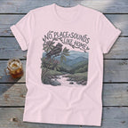 Pink t-shirt with "No Place Sounds Like Home" text, bird on branch, and mountain landscape.