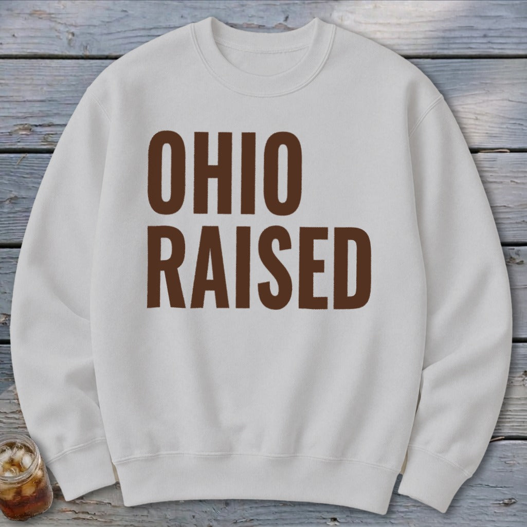 White crewneck sweatshirt with brown text "OHIO RAISED"
