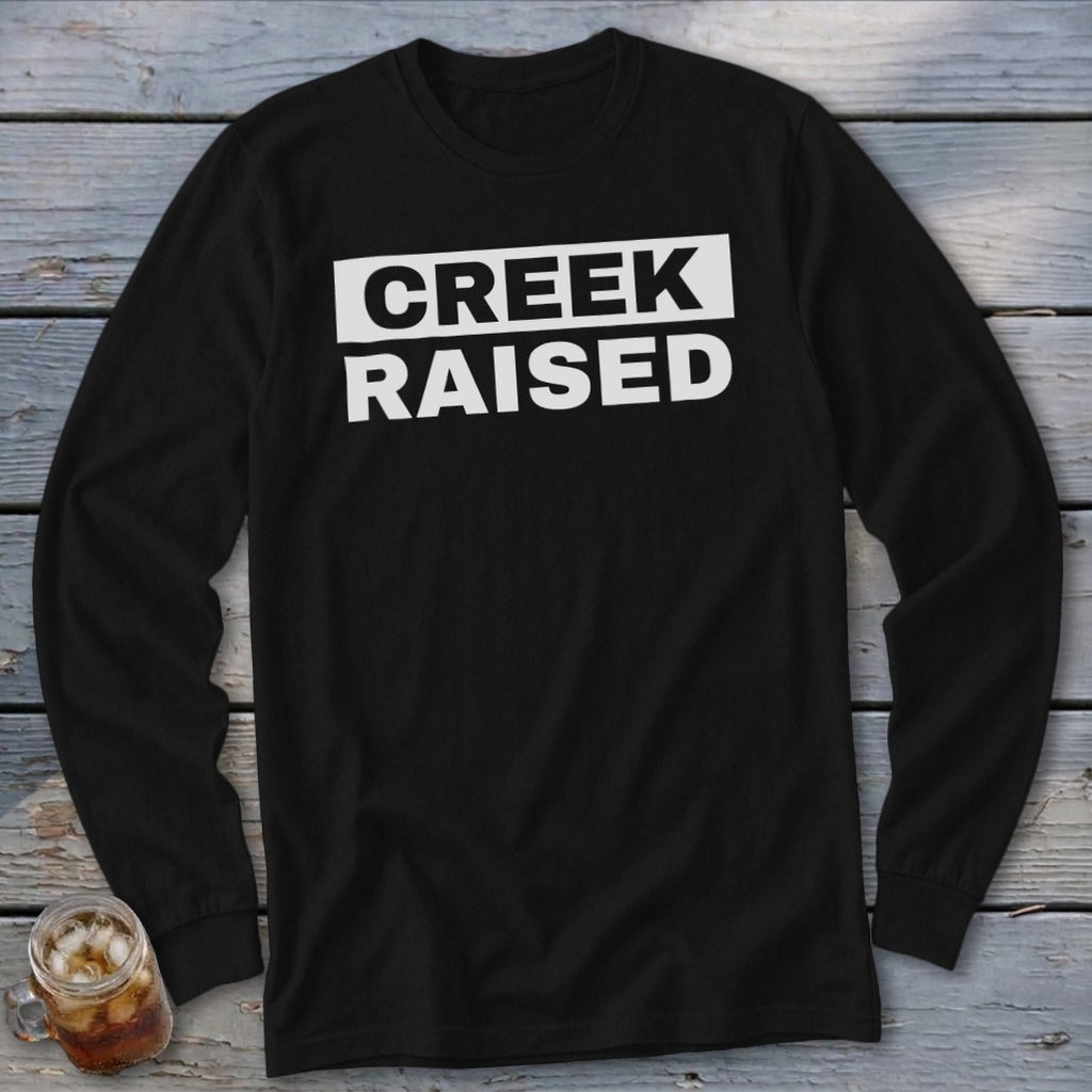 Black long-sleeve shirt with white text "CREEK RAISED"