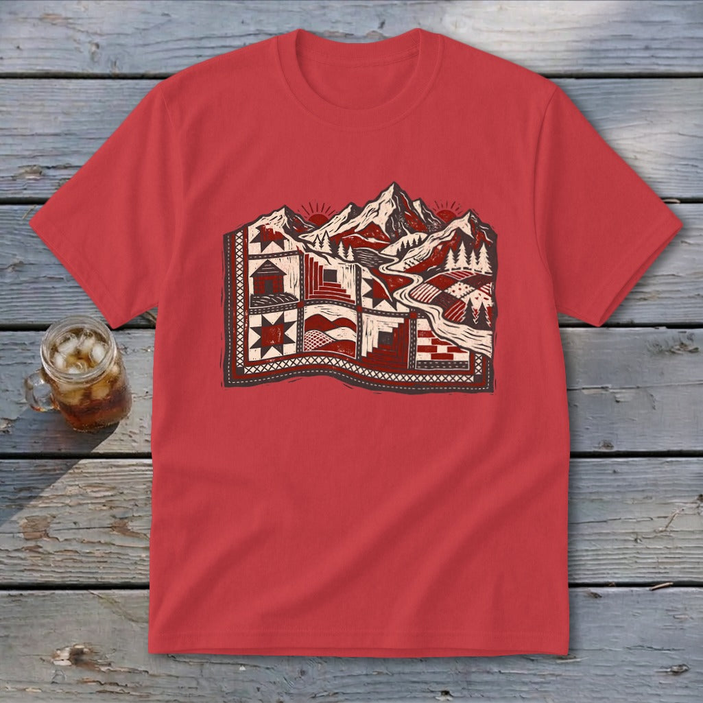 Red crewneck t-shirt featuring a stylized mountain landscape graphic in red and white on a wooden background.