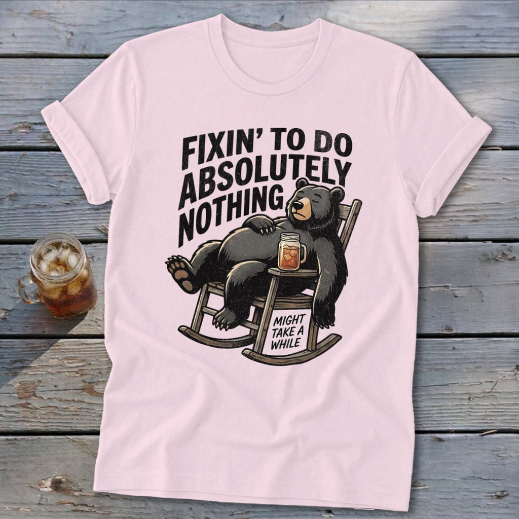 Light pink t-shirt featuring a cartoon black bear relaxing in a rocking chair with text.