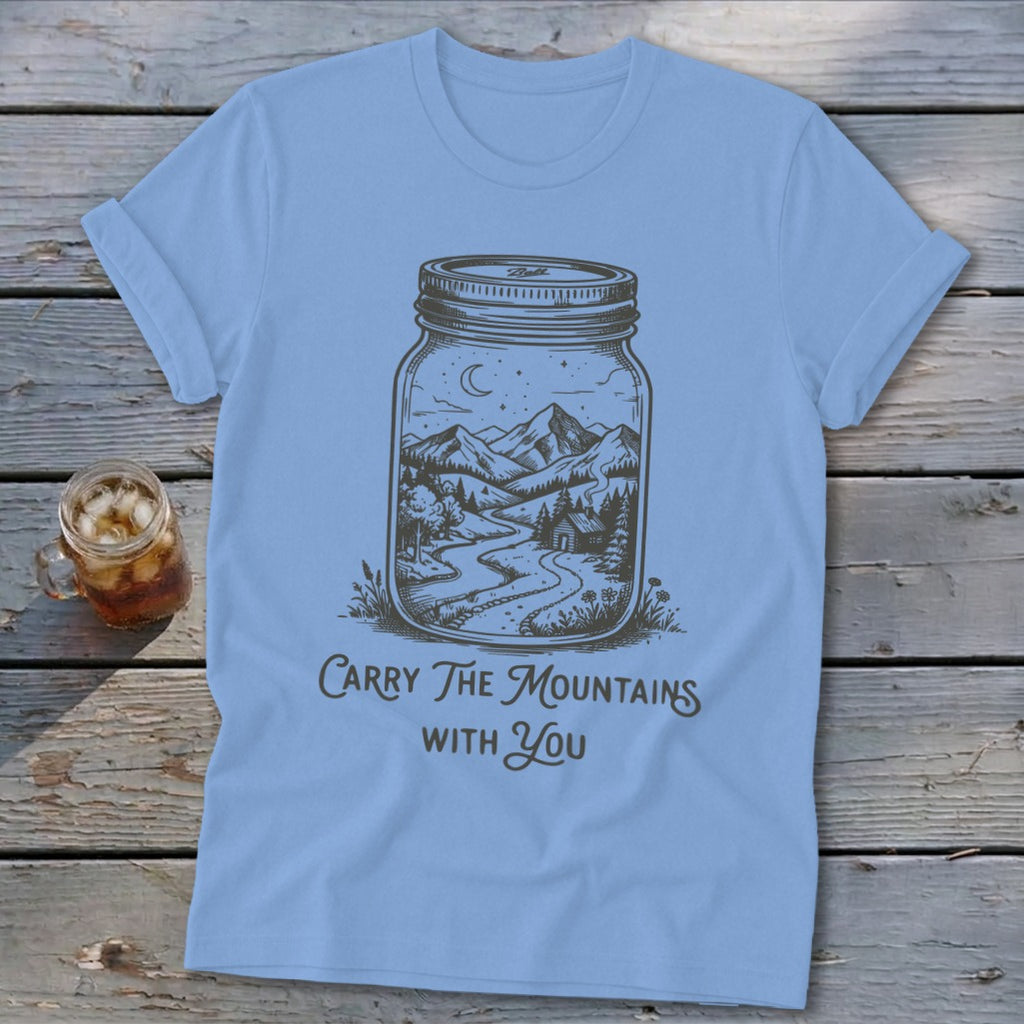 Light blue t-shirt featuring a mason jar graphic containing a mountain landscape and the text Carry The Mountains With You.
