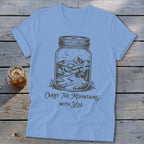 Light blue t-shirt featuring a mason jar graphic containing a mountain landscape and the text Carry The Mountains With You.