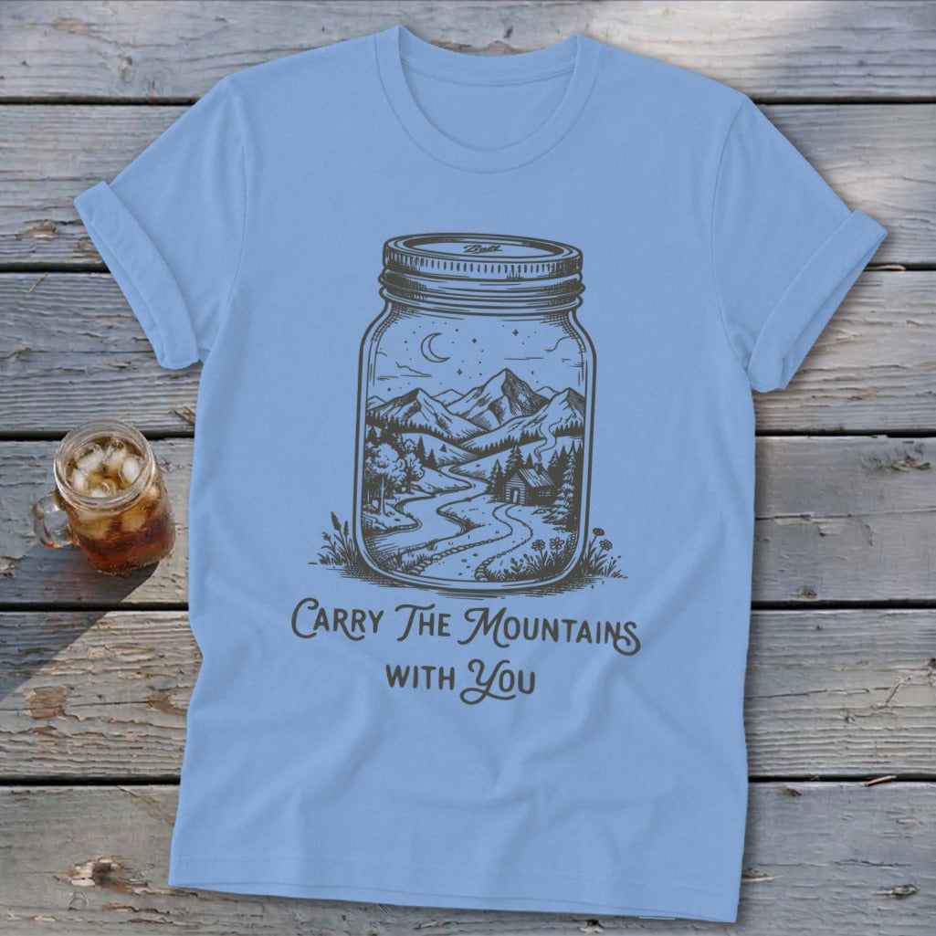 Light blue t-shirt featuring a mason jar graphic containing a mountain landscape and the text Carry The Mountains With You.
