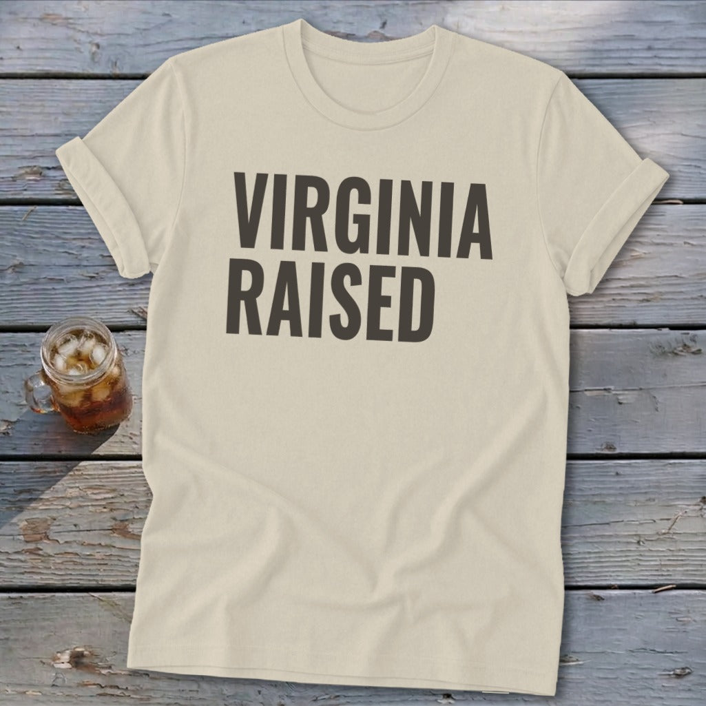 Cream t-shirt with "Virginia Raised" text in dark gray, next to a glass of iced tea.