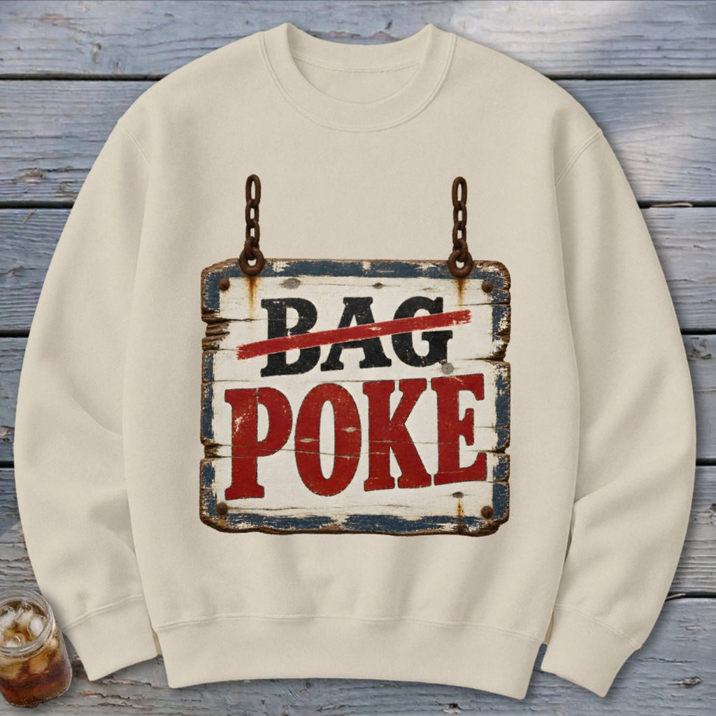 A beige crewneck sweatshirt features a graphic of a rustic wooden sign hanging by chains with text reading "BAG POKE".