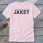 Pink t-shirt with black text reading "Looking A Little Jakey."