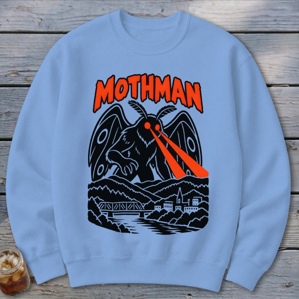 Mothman graphic with orange eyes emitting red beams over a town and bridge.