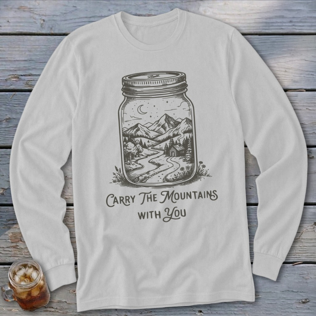 A light gray long-sleeve t-shirt featuring a line drawing of mountains inside a mason jar with the text "Carry The Mountains With You."