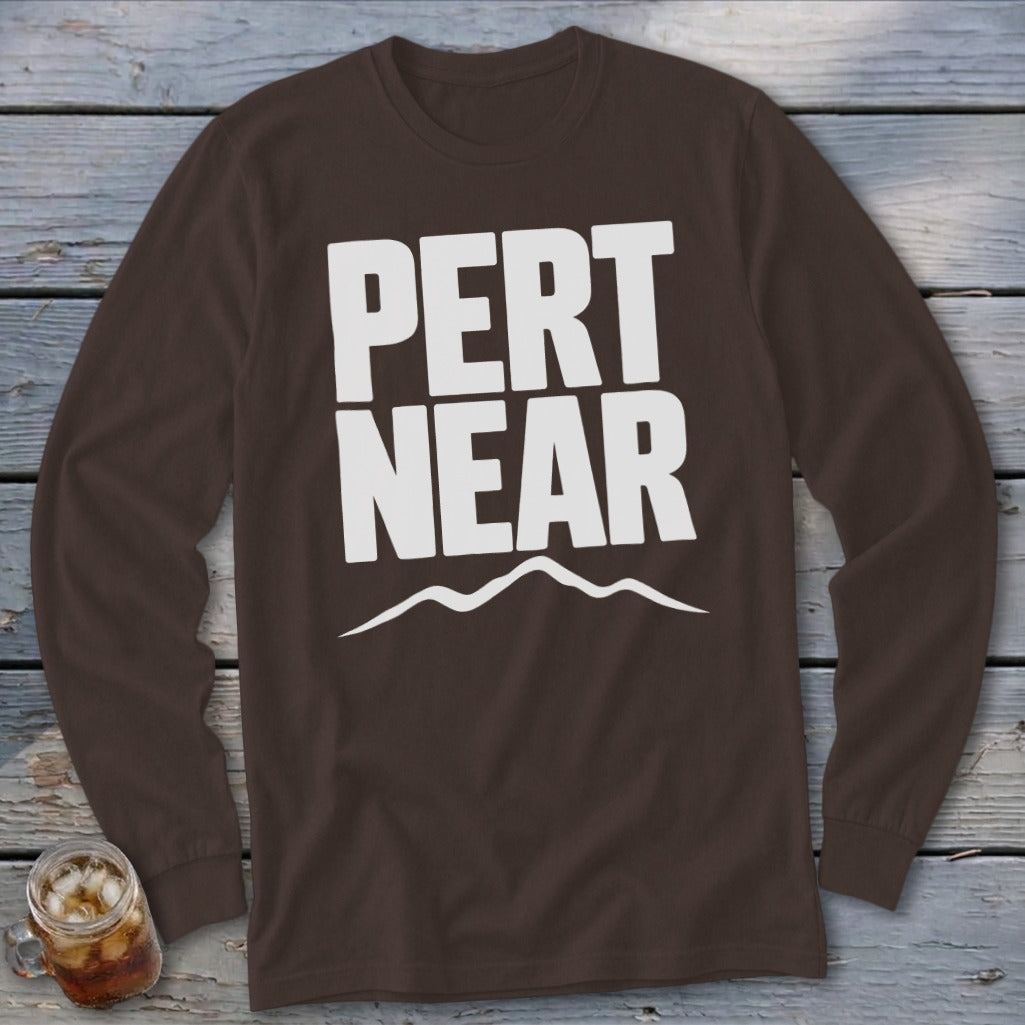 Brown long-sleeve t-shirt with white text reading PERT NEAR above a mountain range graphic.