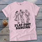 Pink t-shirt with black graphic of three people dancing and the words "FLAT-FOOT DANCING".